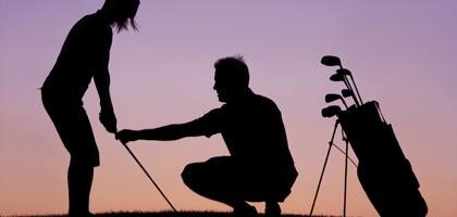 Silhouette of golfers at sunset